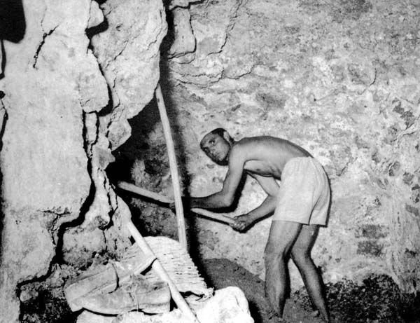 Immagine di un picconiere mentre lavora all'interno di una galleria